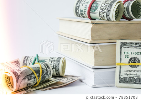 Knowledge leads to wealth. Stack of books with dollars. Concept of expensive education. Money in books. Saving money for college univercity. Knowledge leads to wealth. Stack of books with dollars. Concept of expensive education. Money in books. Saving money for college univercity. 78851708