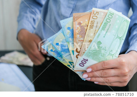 Business Woman Displaying a Spread of Cash euros. Income and Business concept. Venality, bribe, corruption concept. Hand giving money. Millennial candid authentic female hands counting money Business Woman Displaying a Spread of Cash euros. Income and Business concept. Venality, bribe, corruption concept. Hand giving money. Millennial candid authentic female hands counting money 78851710