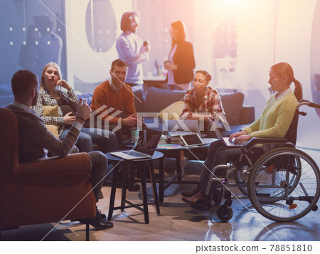 Handicapperd businesswoman in a wheelchair on meeting with her diverse business team brainstorming at office 78851810