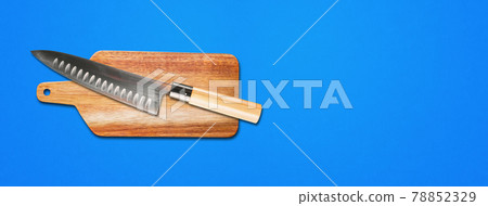 Traditional Japanese gyuto chief knife on a cutting board. Blue banner background 78852329