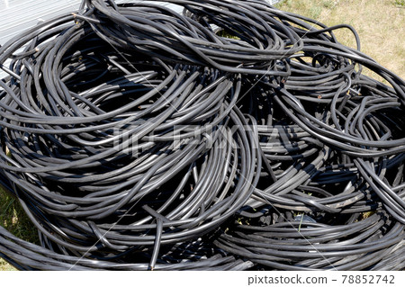 A twisted copper wire in black plastic insulation lies in a pile. Electrification and automation of 78852742