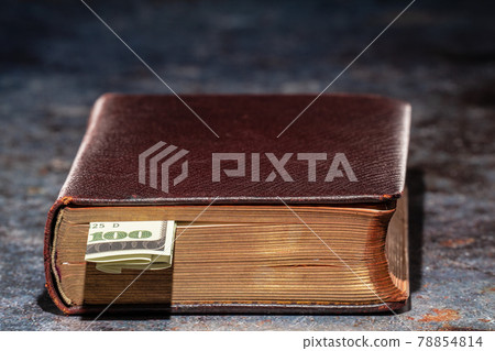 One hundred dollar bookmark note in an old book 78854814