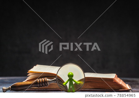A book with a figure of a man visible through a magnifying glass. Knowledge and Education Concept A book with a figure of a man visible through a magnifying glass. Knowledge and Education Concept 78854965