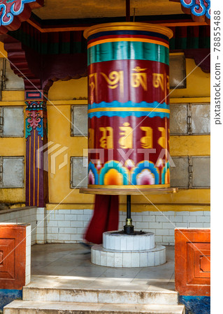 Buddhist monk rotating big prayer wheel 78855488
