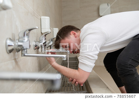 A Muslim takes ablution for prayer. Islamic religious rite 78855607