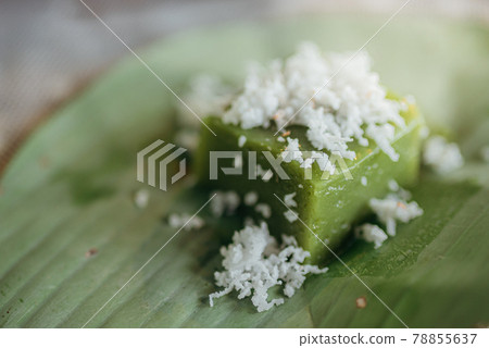 Green coconut sweet pudding decorated with white coconut meat on banana leaf or "Kanom Piak poon". 78855637
