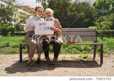 Portrait of young woman with grandmother outdoors in city, life after covid-19 vaccination. Portrait of young woman with grandmother outdoors in city, life after covid-19 vaccination. 78855763