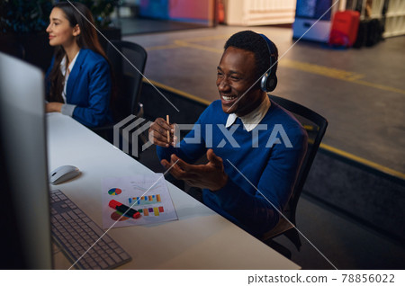 Two smiling managers works in night office Two smiling managers works in night office 78856022