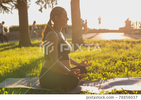Young pregnant woman meditating in nature, practice yoga. Care of health and pregnancy 78856037
