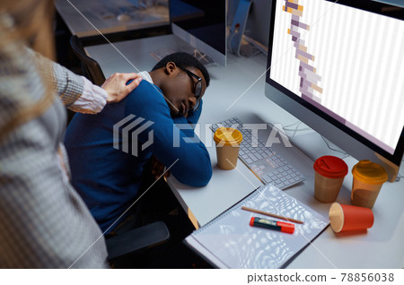 Woman looks on sleeping manager, night office Woman looks on sleeping manager, night office 78856038