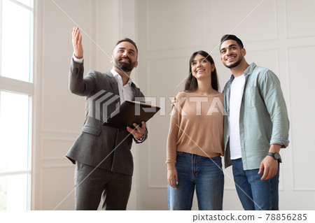 Estate Agent In Suit Showing Buyers New Apartment 78856285