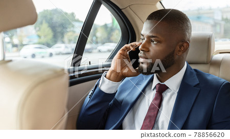 Pensive black manager going to office, having phone conversation Pensive black manager going to office, having phone conversation 78856620