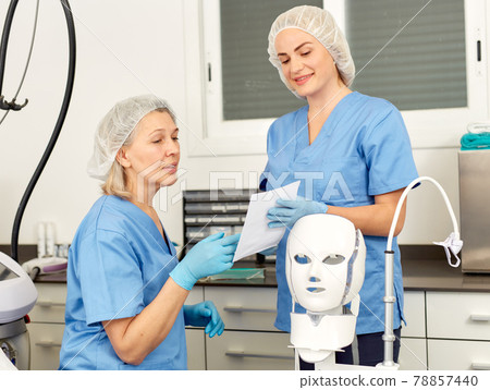 Portrait of qualified females cosmetologists smiling confidently in medical center 78857440