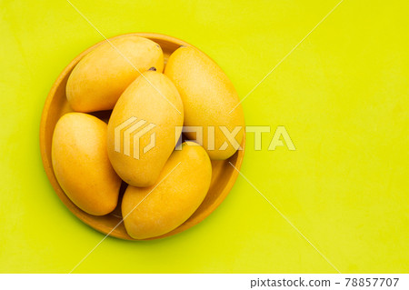 Tropical fruit, Mango in yellow plate on green background. Tropical fruit, Mango in yellow plate on green background. 78857707