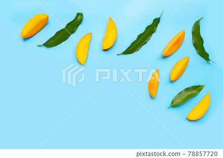 Tropical fruit, Mango slices with leaves on blue background. Tropical fruit, Mango slices with leaves on blue background. 78857720
