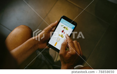 man makes his shopping list in the washroom 78858650