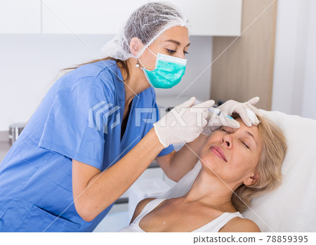 Mature female receiving cosmetic injection 78859395