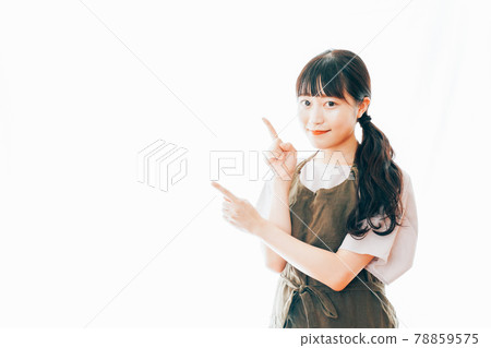 穿圍裙和指著她的手指的年輕女人 78859575