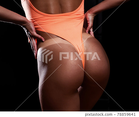 A faceless woman in an orange swimsuit demonstrates the result of an instant tan A faceless woman in an orange swimsuit demonstrates the result of an instant tan 78859641