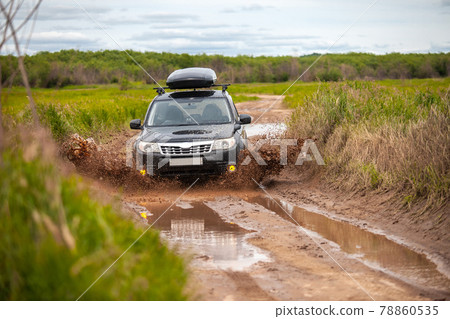 Black Subaru Forester moving at dirty forest road making a lot of water splashes Black Subaru Forester moving at dirty forest road making a lot of water splashes 78860535