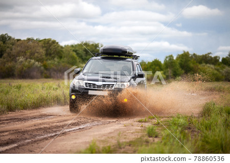 Black Subaru Forester moving at dirty forest road making a lot of water splashes Black Subaru Forester moving at dirty forest road making a lot of water splashes 78860536
