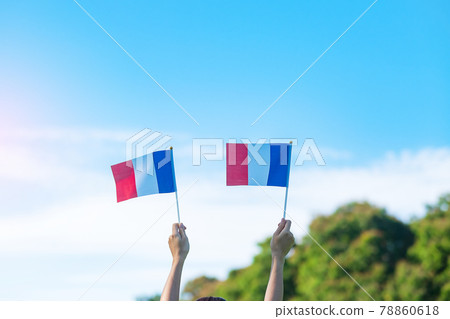 hand holding France flag on blue sky background. holiday of French National Day, Bastille Day and happy celebration concepts hand holding France flag on blue sky background. holiday of French National Day, Bastille Day and happy celebration concepts 78860618