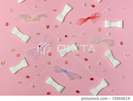 Pink paper background with paper and fabric ribbons and beads. Pink paper background with paper and fabric ribbons and beads. 78860619