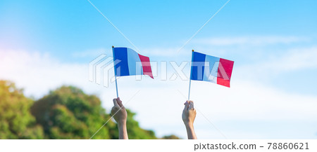 hand holding France flag on blue sky background. holiday of French National Day, Bastille Day and happy celebration concepts 78860621