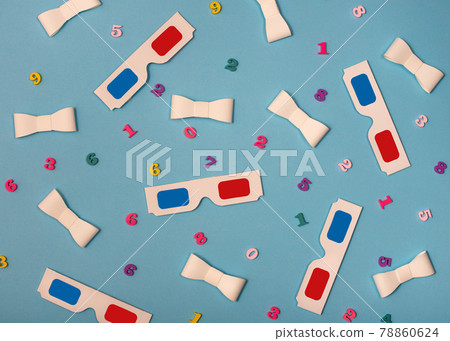 Flat lay composition with 3D glasses, paper ribbons and wooden colored numbers on blue background. 78860624