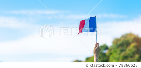 hand holding France flag on blue sky background. holiday of French National Day, Bastille Day and happy celebration concepts hand holding France flag on blue sky background. holiday of French National Day, Bastille Day and happy celebration concepts 78860625
