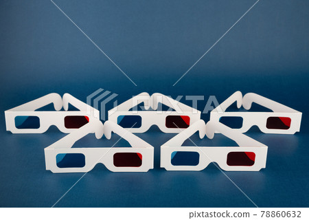 Minimalist composition with classic paper 3D movie glasses on dark blue background. 78860632