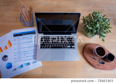 Office laptop business financial document chart and graph on wooden table with coffee cup. Flat lay notebook computer laptop on office desk. No people business graph chart mockup on business workspace Office laptop business financial document chart and graph on wooden table with coffee cup. Flat lay notebook computer laptop on office desk. No people business graph chart mockup on business workspace 78861903