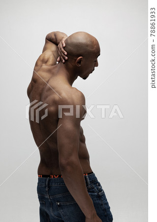 Portrait of young muscled African man, fashion model isolated over white background. Back view Portrait of young muscled African man, fashion model isolated over white background. Back view 78861933