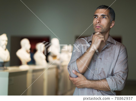 Adult male is visiting at the pictures exposition 78862937