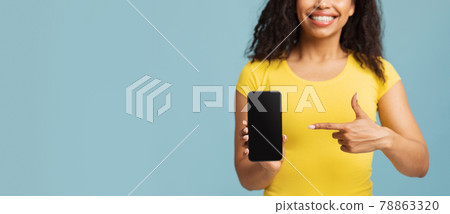 Choose this. Happy african american woman pointing on blank phone screen on blue background, panorama with free space Choose this. Happy african american woman pointing on blank phone screen on blue background, panorama with free space 78863320