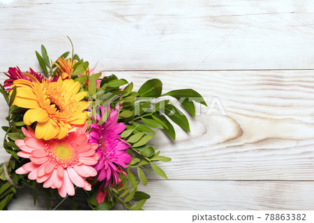 Beautiful bouquet of multi colored gerbera flowers on wooden background. 78863382