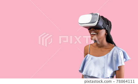 Young black woman in virtual reality glasses playing online game, feeling excited on pink background, banner design 78864111
