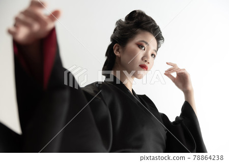 Portrait of young beautiful Japanese, woman in national attire kimono posing isolated over white studio background. Portrait of young beautiful Japanese, woman in national attire kimono posing isolated over white studio background. 78864238