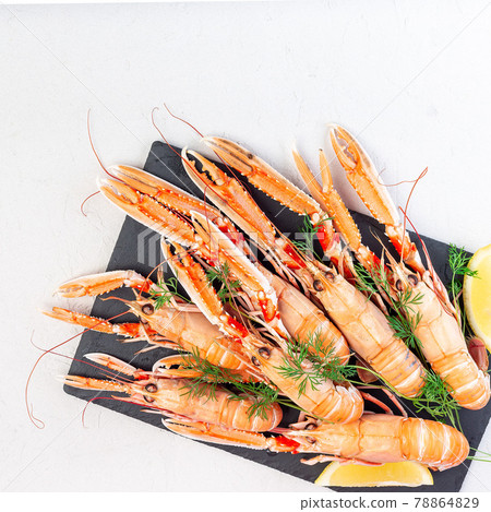 Sea crayfishes on a stone plate served with dill and lemon, top view, copy space, square 78864829