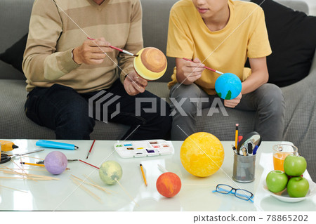 Father and Son Making Solar System Model 78865202