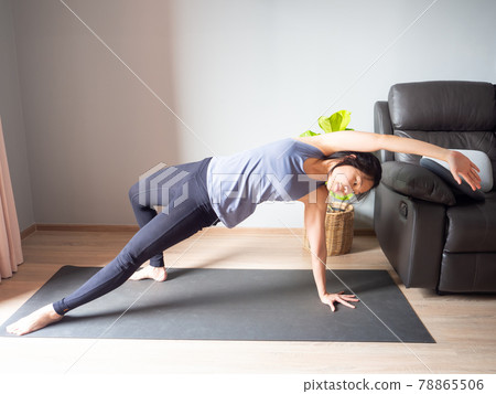 wild thing Camatkarasana yoga pose asian woman home workout fitness body weight exercise health training sport healthy lifestyle activity wellness care on mat indoors natural light selective focus 78865506