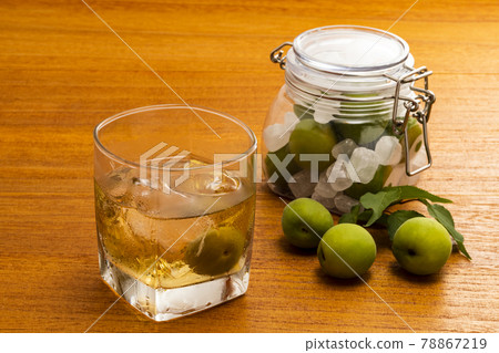 A glass of plum wine with ice and a bottle of plum wine 78867219