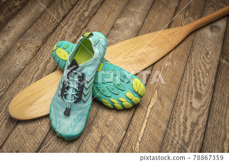 water shoes and wooden canoe paddle 78867359
