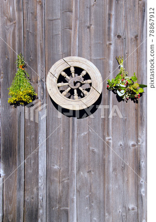 tutsan and raspberry bunches and wheel on wall 78867912