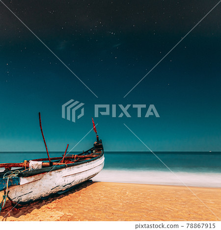 Goa, India. Real Night Sky Stars. Natural Starry Sky Blue Color Above Sea Seascape Ocean Beach. Background. Parked Old Wooden Boat At Coast Goa, India. Real Night Sky Stars. Natural Starry Sky Blue Color Above Sea Seascape Ocean Beach. Background. Parked Old Wooden Boat At Coast 78867915