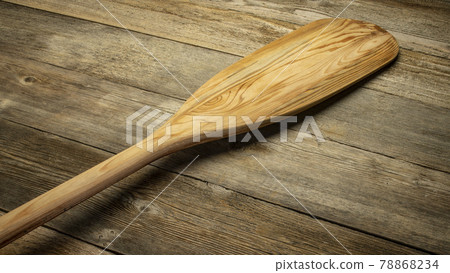 wooden canoe paddle against rustic wood 78868234