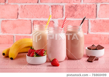Set of strawberry banana and chocolate milkshakes in glass jars 78868499