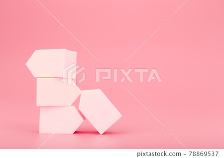 Stack of white make up sponges on pink background with copy space 78869537