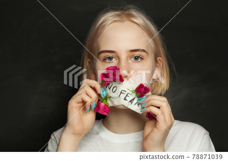Attractive young girl with patch and red flowers on her mouth on black background Attractive young girl with patch and red flowers on her mouth on black background 78871039