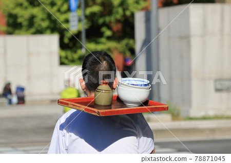 Delivery of a soba restaurant, picking up a bowl, back view Delivery of a soba restaurant, picking up a bowl, back view 78871045